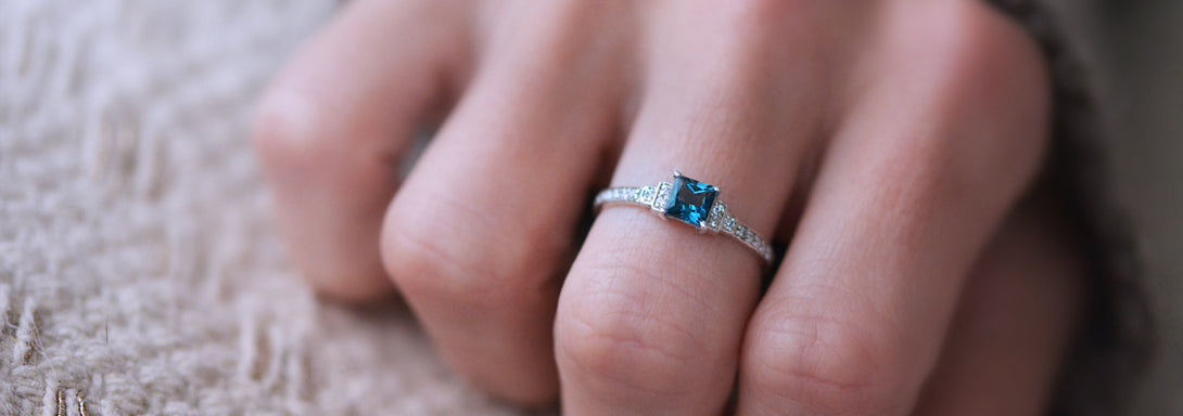 Photo portée d'un solitaire en or blanc palladié 18 carats serti d'une topaze blue london carrée /4| Faventine Joaillerie en ligne personnalisable