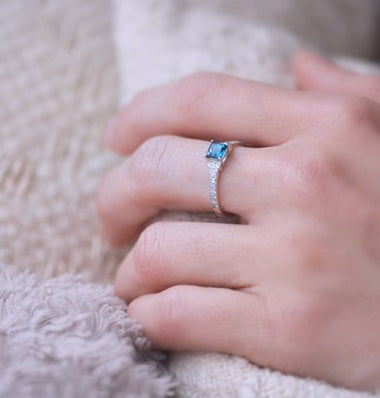 Photo portée d'un solitaire en or blanc palladié 18 carats serti d'une topaze blue london carrée /3| Faventine Joaillerie en ligne personnalisable