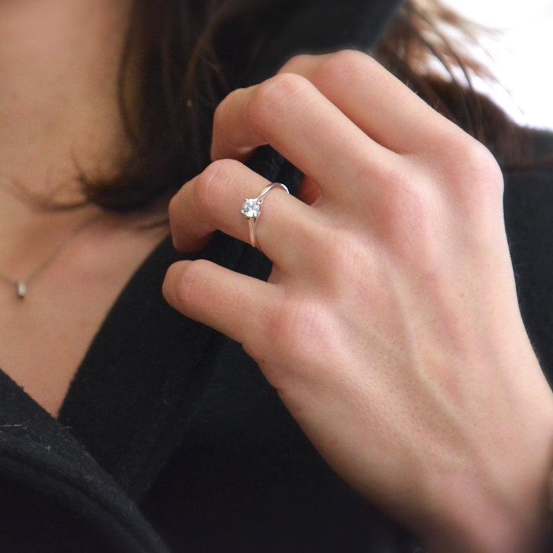 Photo portée d'un solitaire en or gris palladié 18 carats serti d'un diamant central de 4 mm 