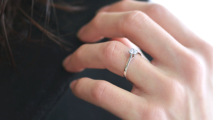 Photo portée d'un solitaire en or gris palladié 18 carats serti d'un diamant central de 4 mm /2| Faventine Joaillerie en ligne personnalisable